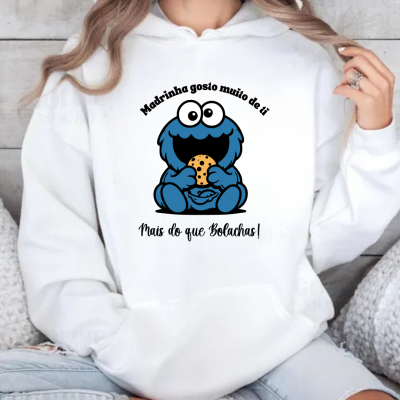 Sweatshirt branca com estampa de monstro azul segurando bolacha e texto em português.