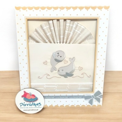 Conjunto de fraldas com desenho de focas numa caixa decorada, etiqueta da marca Pirralhos