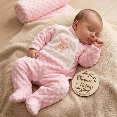 Bebé a dormir com macacão rosa e placa de madeira com texto Cheguei ao Mundo