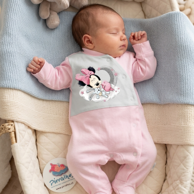 Bebé vestido com macacão cor-de-rosa com desenho da Minnie Mouse, a dormir num colchão acolchoado creme com manta cinza e brinquedo elefante de peluche