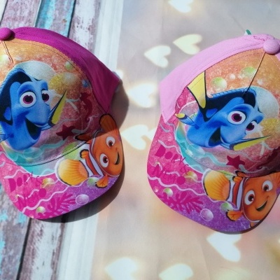 Duas chapéus de criança cor-de-rosa com personagens Dory e Nemo do filme 'Procurando Nemo'.