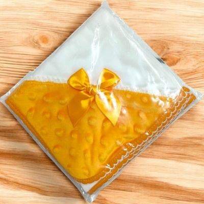 Manta de bebé amarela com laço embalada em plástico