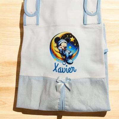 Fralda branca e azul com ilustração de Mickey, nome Xavier e detalhes em fita azul