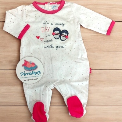 Macacão de bebé branco com pontos coloridos e detalhes rosas.