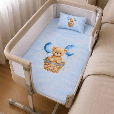 Berço de bebé com roupa de cama azul e desenho de ursinho com balões