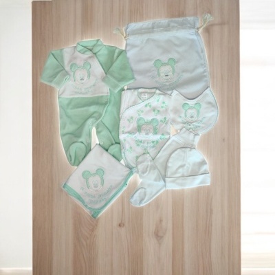 Conjunto de roupa para bebé verde e branco com urso e saco no fundo de madeira