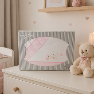 Manta de bebé branca e rosa em caixa Baby Look sobre cómoda branca com urso de peluche.