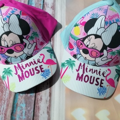Dois bonés infantis da Minnie Mouse, um rosa e outro azul claro, com desenho e texto colorido.