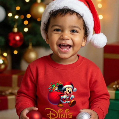 Camisola vermelha infantil com estampa de Mickey Mouse Pai Natal e texto Dinis, criança com gorro de Natal e bolas natalícias.