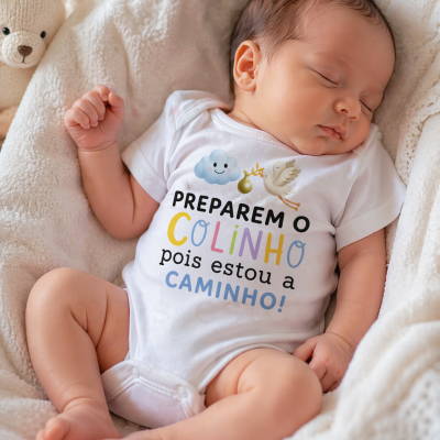 Bebé a dormir com body branco estampado colorido e ursinho de peluche ao lado