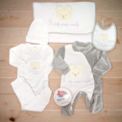 Conjunto de roupa para bebé branco e cinza com ursinho bordado sobre madeira clara