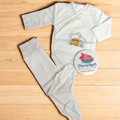 Conjunto de roupa de bebé branca com ursinho estampado e etiqueta da marca Pirralhos