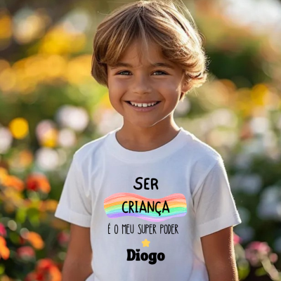 Camisola branca com texto colorido vestida por criança sorridente em jardim