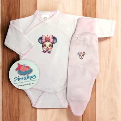 Roupa de bebé com estampa de personagem infantil em fundo de madeira.