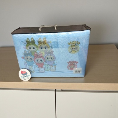 Bolsa azul com personagens animados BUBU e etiqueta Pirulitos sobre móvel de madeira