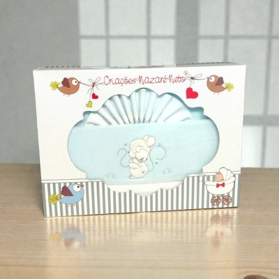 Conjunto de roupa de bebé azul claro com bordado de rato numa caixa decorada.