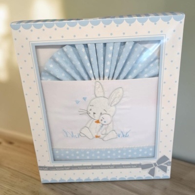 Conjunto de têxteis para bebé azul claro com bordado de coelho em embalagem decorada.
