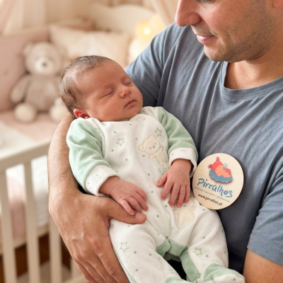 Bebé recém-nascido a dormir com pijama branco e verde com ursinhos e estrelas num quarto de bebé