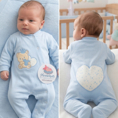 Bebé de macacão azul claro com urso bordado e coração estampado.