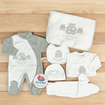 Conjunto de roupa de bebé branco e cinza com ursinhos bordados e manta, disposição em fundo de madeira