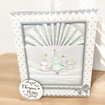 Conjunto de fraldas de bebé com bordado de animais e estrela em caixa branca com bolinhas cinzentas.