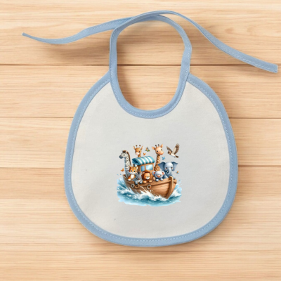 Babete branco com borde azul e ilustração de barco com animais em fundo de madeira