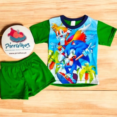 Conjunto infantil com t-shirt do Sonic e calções verdes sobre fundo de madeira