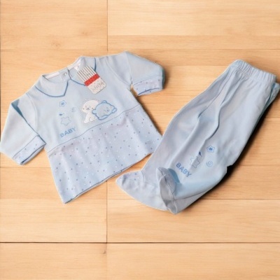 Conjunto de roupa de bebé azul claro com camisola e calças sobre piso de madeira