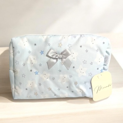 Necessaire azul claro com padrão de estrelas e nuvens, laço prateado e etiqueta 'Miranda'