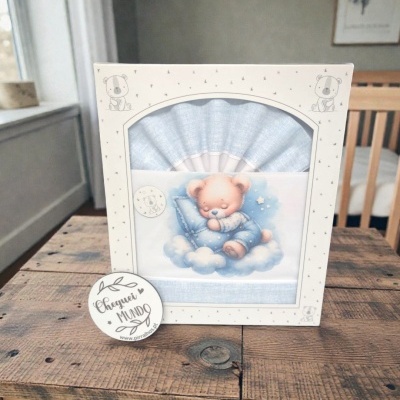 Conjunto de roupa de bebé azul claro com ursinho a dormir em nuvem e embalagem decorada com ursinhos e estrelas.