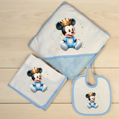 Conjunto de bebé com toalha, fralda e babete brancos com bordas azuis e estampa de rato com coroa.
