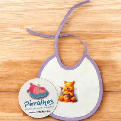 Babete branco com contorno roxo e estampa do Ursinho Pooh segurando pote de mel, com chapa redonda da marca Pirralhos.
