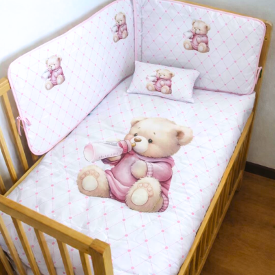 Berço de madeira com roupa de cama infantil com ursinhos e padrão xadrez rosa