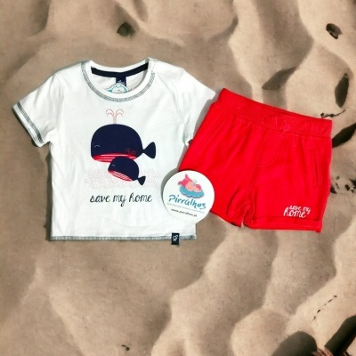 Conjunto infantil t-shirt branca estampada e calções vermelhos sobre areia com conchas