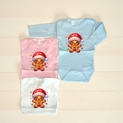 Três bodies para bebé com estampa de biscoito de gengibre natalício em azul claro, rosa e branco.