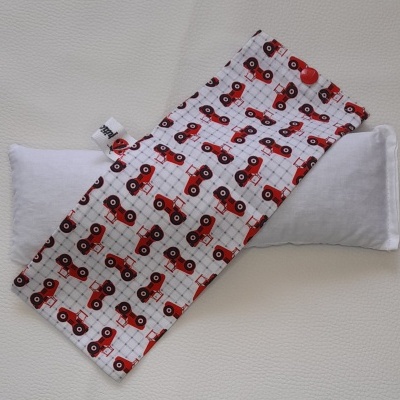 Capa de tecido branco com padrão de tratores vermelhos e almofada branca.
