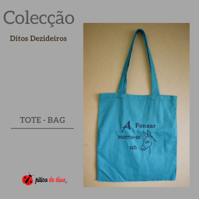 Saco tote azul com texto e desenho de burro sobre fundo bege