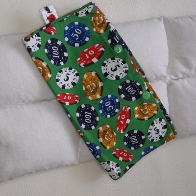 Produto têxtil com padrão de fichas de poker sobre almofadas brancas acolchoadas