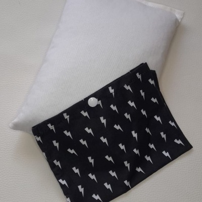 Almofada branca com capa preta decorada com raios brancos e botão