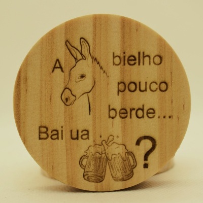 Disco redondo de madeira com gravura de burro, duas canecas de cerveja e texto em português.