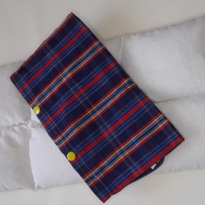 Travesseiro branco com tecido listrado azul, vermelho e branco com botões amarelos