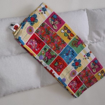 Almofada branca subdividida em quatro quadrados com tecido colorido estampado