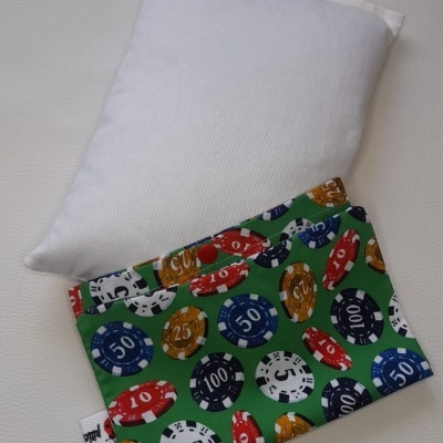 Almofada branca com capa verde estampada com fichas de poker coloridas