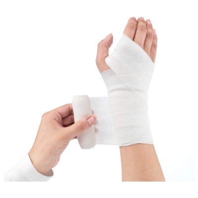 Mãos a enrolar uma faixa elástica branca no pulso