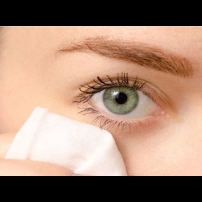 Olho verde com pestanas longas e lenço branco próximo ao rosto