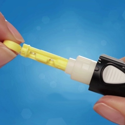 Dispositivo de teste com cartucho amarelo removível segurado por mãos