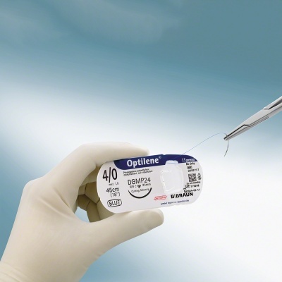 Mão com luva segurando embalagem de fio de sutura Optilene 4/0 da B Braun