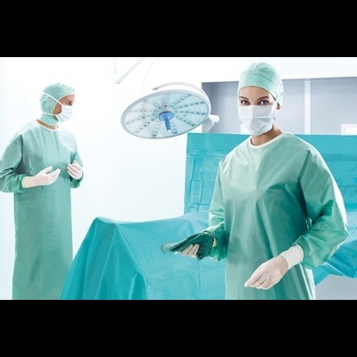 Profissionais de saúde em sala de operação com equipamento cirúrgico e mesa coberta