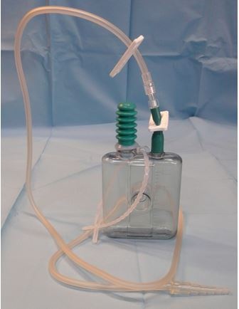 Frasco plástico transparente com tampa verde e tubos flexíveis em fundo azul