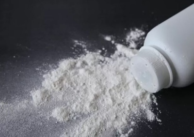 Frasco branco com pó branco espalhado em superfície escura